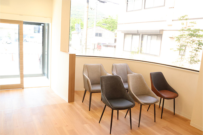 白を基調とした壁と木目調のインテリアが調和するカフェのような温かい雰囲気の待合室です。診療まで、ゆったりとくつろいでお過ごしください。